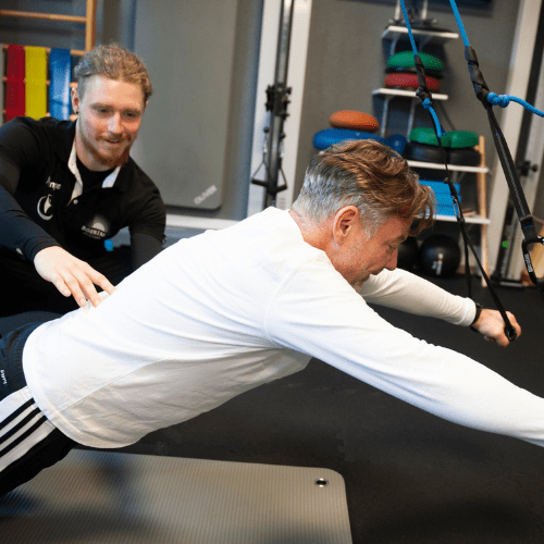 Personal Trainer korrigiert die Übungsausführung im 1:1-Coaching